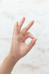 Top view: female hand with clean healthy skin on a white isolated background showing gestures with fingers. The gesture is good, good, I agree.