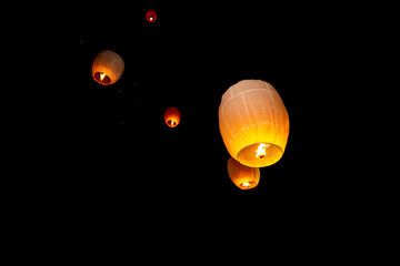 Colorful circle paper floating lanterns are flying to dark night skies in Probarona Purnima festival.