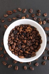 Coffee beans and bowl on stone background. Top view with copy space for your text