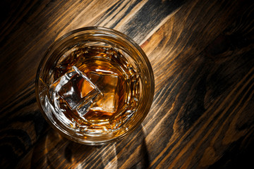 glass with whiskey and ice on the table