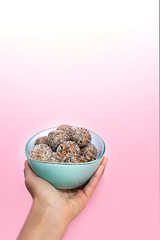 Hand with healthy energy balls or protein peanut butter energy bites.