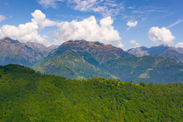 Wide Angle Panorama Alps Mountains on the Background and Trees in the foreground. Travel Postcard Concept