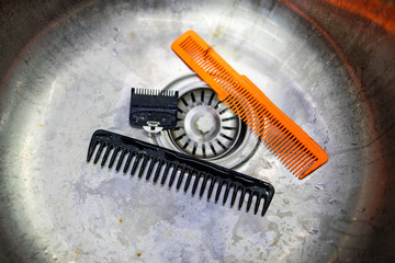 Two Combs in the sink after a haircut in a hair salon.