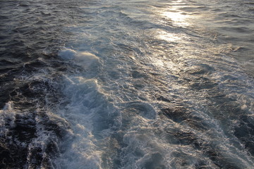 The dark waters of the Mediterranean Sea sway and foam and the waves play with the golden rays of the spring sun.