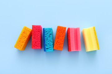 Colored kitchen sponges on blue background. Kitchen cleaning set