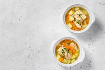 two ceramic pots  of  fish soup. Top view, copy space.