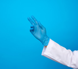 medic in a white coat, blue latex gloves pulls his hand up