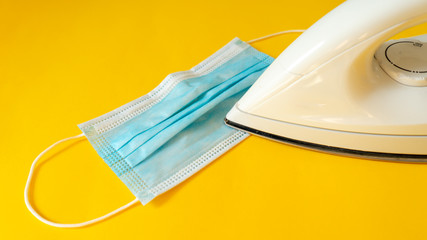 Disinfection of a disposable medical mask with an iron. Prevent the spread of germs, bacteria and coronaviruses. Coronavirus Prevention.