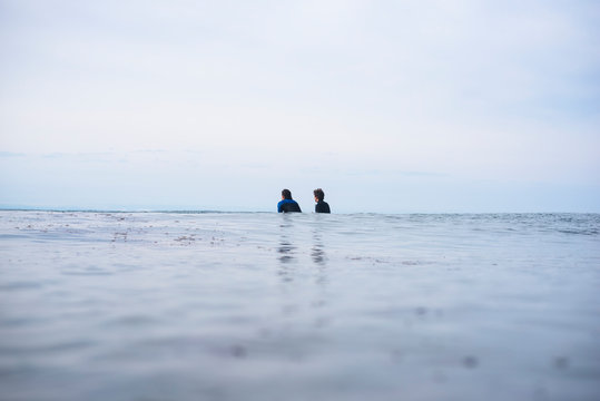 Two friends waiting for waves in the ocean