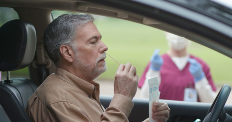 A new concept in mobile testing for coronavirus being performed by a mature man in a do it yourself procedure that reduces the need for HCP and PPE by swabbing ones own nostrils.