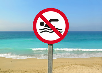 No swimming sign at the beach. Warning sign prohibiting swimming on the beach. Red sign...