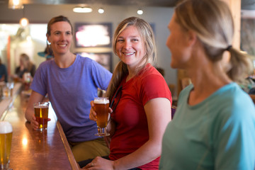 Three female friends enjoy a beer at a brewery in Government Camp, OR.