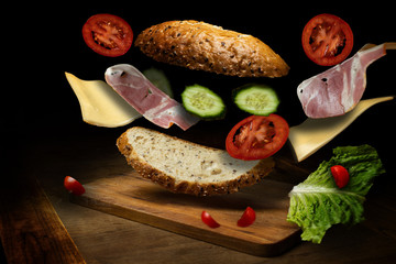 flying sandwich in air , lot of bacon and fresh vegetables 