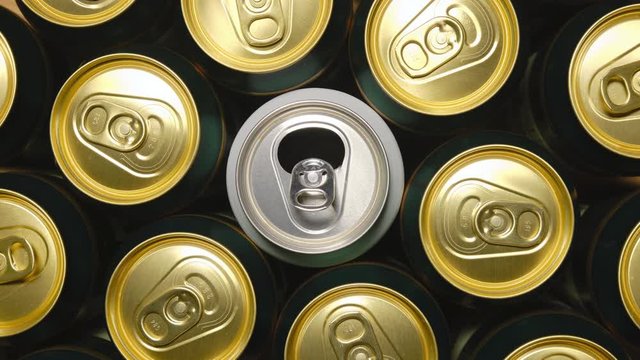 Aluminium beer or soda cans, looping stop motion. Open white can spinning in the middle, with yellow and green cans spinning in the opposite direction. Concept for beer/soda production or consumerism.