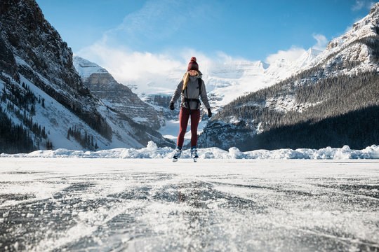 Woman Ice Skating on Frozen Lake at Lake Louse in Banff National Park