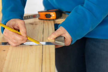 Una persona mide con la escuadra y marca con el lápiz.