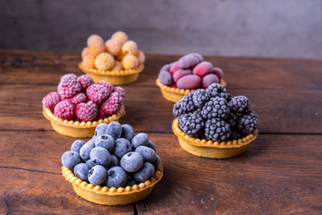 Frozen blueberries, blackberries, red and yellow raspberries in waffle tartlets.