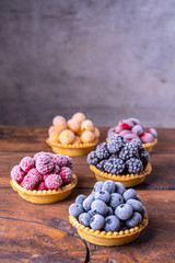Frozen blueberries, blackberries, red and yellow raspberries in waffle tartlets.