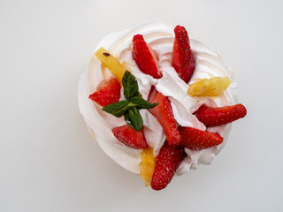 Close-up shot of creamy cake with fruits on white background. Space for text