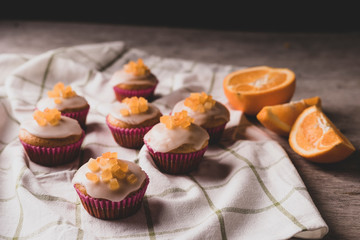 Candied fruit orange muffins on a white towel.	