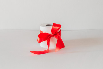 white toilet paper with a red bow on a white background.