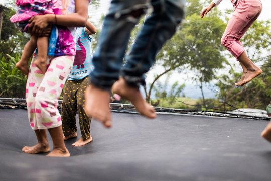 kids jumping on backyard trampoline.