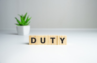 the word duty wooden cubes, duties of people, gray background top view