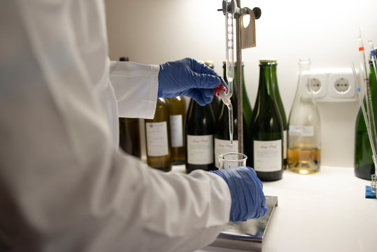 Close up of lab technician by placing a sample on beaker.
