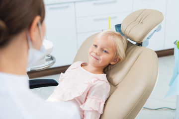 Little cute female child sitting in a sitting at a dentistry