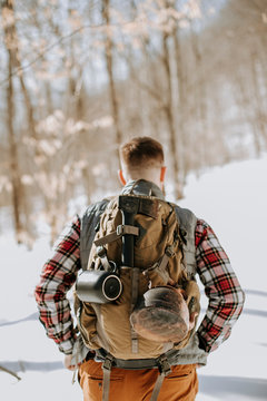 closeup of man wearing pack and flannel in snow covered woods