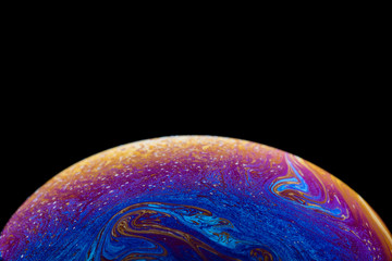 Burbuja de jabón simulando la atmosfera de un planeta con diferentes formas, colores y el fondo negro