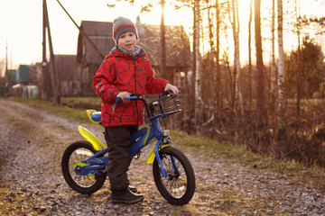 Boy on bike. Child is riding on street. Happy child is playing outdoors.