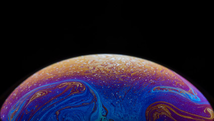 Burbuja de jabón simulando la atmosfera de un planeta con diferentes formas, colores y el fondo negro © Edgar1 BJ