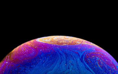 Burbuja de jabón simulando la atmosfera de un planeta con diferentes formas, colores y el fondo negro