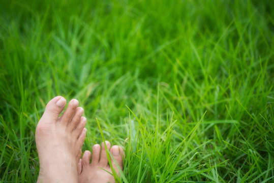 Barefoot, relaxing in the meadow, green grass field