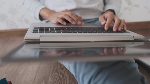 Mom and son sit at home quarantine because of coronavirus COVID19. Mother works remotely with laptop, son plays with toy blocks. Self isolation at home.
