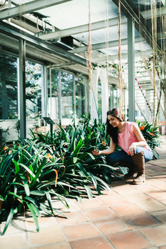 Close up of a beautiful agronomical engineer observing the plants in the greenhouse