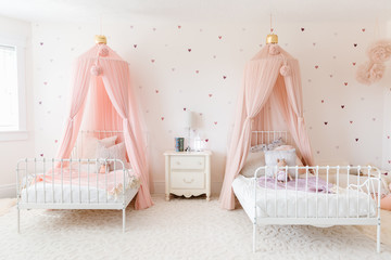 sister room with matching beds and pink canopies