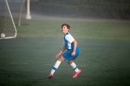 Teen Soccer Player Ready To Defend On A Foggy Field