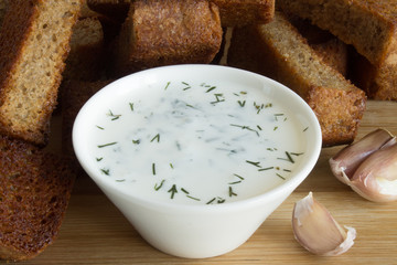Fried breadcrumbs and garlic sauce with dill in a white Cup close up