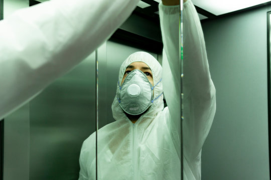 coronavirus. Worker disinfecting hospital elevator to avoid contagion.