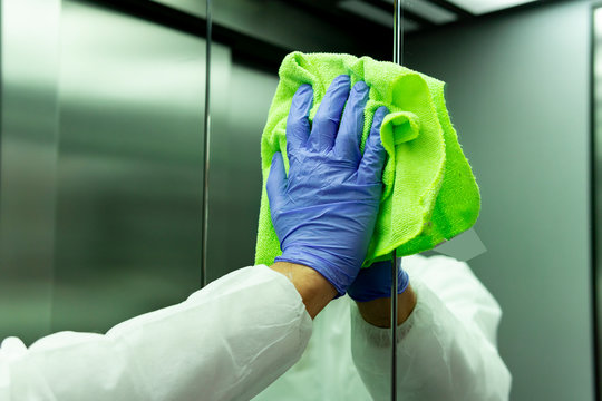 coronavirus. Worker disinfecting hospital elevator to avoid contagion.