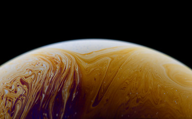 Burbuja de jabón simulando la atmosfera de un planeta con diferentes formas, colores y el fondo negro © Edgar1 BJ