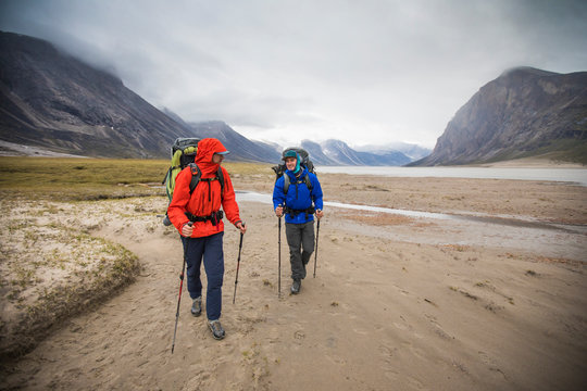 Front view of backpackers hiking in the rain, Baffin Island, Canada.