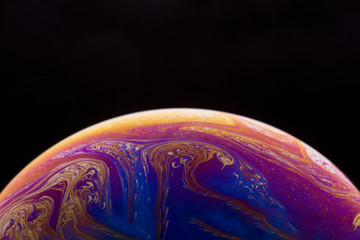 Burbuja de jabón simulando la atmosfera de un planeta con diferentes formas, colores y el fondo negro © Edgar1 BJ