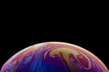 Burbuja de jabón simulando la atmosfera de un planeta con diferentes formas, colores y el fondo negro
