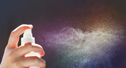 Spray atomizer in female hand. Water particles in the air. Spray with a water, panoramic view - obrazy, fototapety, plakaty
