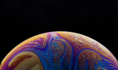 Burbuja de jabón simulando la atmosfera de un planeta con diferentes formas, colores y el fondo negro © Edgar1 BJ