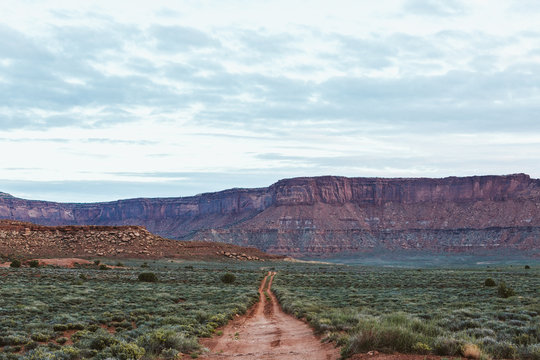 straight red two track dirt road headed off to nowhere in utah desert