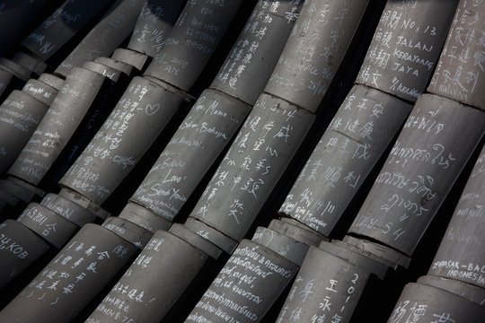 written prayers on roof tiles stacked up at a Buddhist Temple